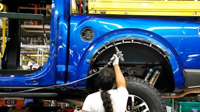 An assemblyman works on a 2018 Ford F-150 truck at the Ford Rouge assembly plant, Dearborn, Mich., Sept. 27, 2018.