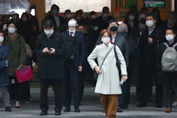 People wait at a crossing in Tokyo, Feb. 15, 2021.