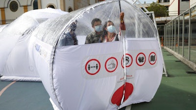 Designers stand inside a Portable Epidemiological Insulation Unit during a media presentation, Bogota, Colombia, Feb. 16, 2021.