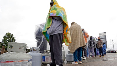 Carlos Mandez waits in line to fill propane tanks, Houston, Feb. 17, 2021.