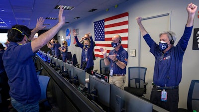 Members of NASA's Perseverance rover team react in mission control after receiving confirmation the spacecraft successfully touched down on Mars, Feb. 18, 2021, NASA's Jet Propulsion Laboratory, Pasadena, Calif.