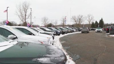 Cars drive through the used vehicle lot at a LaFontaine auto dealership in Fenton Township, Mich., Jan. 28, 2021.