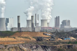 In this file photo, giant machines dig for brown coal at the open-cast mining Garzweiler in front of a smoking power plant near the city of Grevenbroich in western Germany.