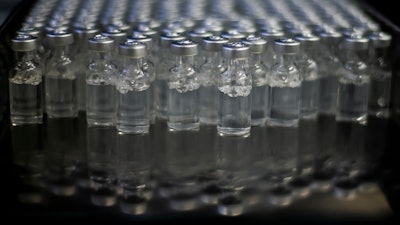 In this file photo doses of AstraZeneca vaccines for COVID-19 sit in vials.