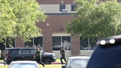Law enforcement officers respond to Santa Fe High School after an active shooter was reported on campus, May 18, 2018, Santa Fe, Texas.
