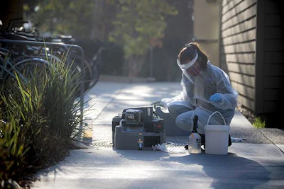 Smruthi Karthikeyan, PhD, picks up wastewater samples from a collection point on the UC San Diego campus.