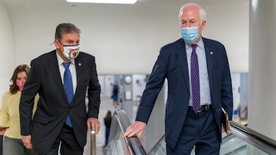 Sens. Joe Manchin, D-W.Va., left, and John Cornyn, R-Texas, head to the Senate chamber, March 5, 2021.