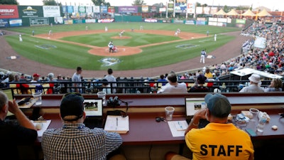 Ron Besaw, right, operates a laptop as home plate umpire Brian deBrauwere gets signals from radar for ball and strike calls during the Atlantic League All-Star Game, York, Pa., July 10, 2019.