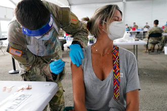 Liana Fonseca looks away as she receives the Pfizer COVID-19 vaccine in Miami, March 9, 2021.