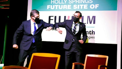 N.C. Gov. Roy Cooper, left, elbow-bumps with Martin Meeson, CEO of Fujifilm Diosynth Biotechnologies, Holly Springs, N.C., March 18, 2021.