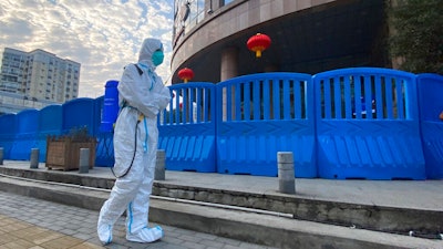 A worker carrying disinfecting equipment walks outside the Wuhan Central Hospital, Wuhan, China, Feb. 6, 2021.