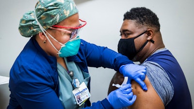 A nurse administers a dose of the Pfizer COVID-19 vaccine at Texas Southern University in Houston, Feb. 11, 2021.