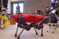 In a frame grab from video, robots walk across the floor of the University of Michigan's Ford Motor Co. Robotics Building, March 12, 2021 in Ann Arbor, Mich. The four-story, $75 million, 134,000-square-foot complex has three floors that house classrooms and research labs for robots that fly, walk, roll and augment the human body.