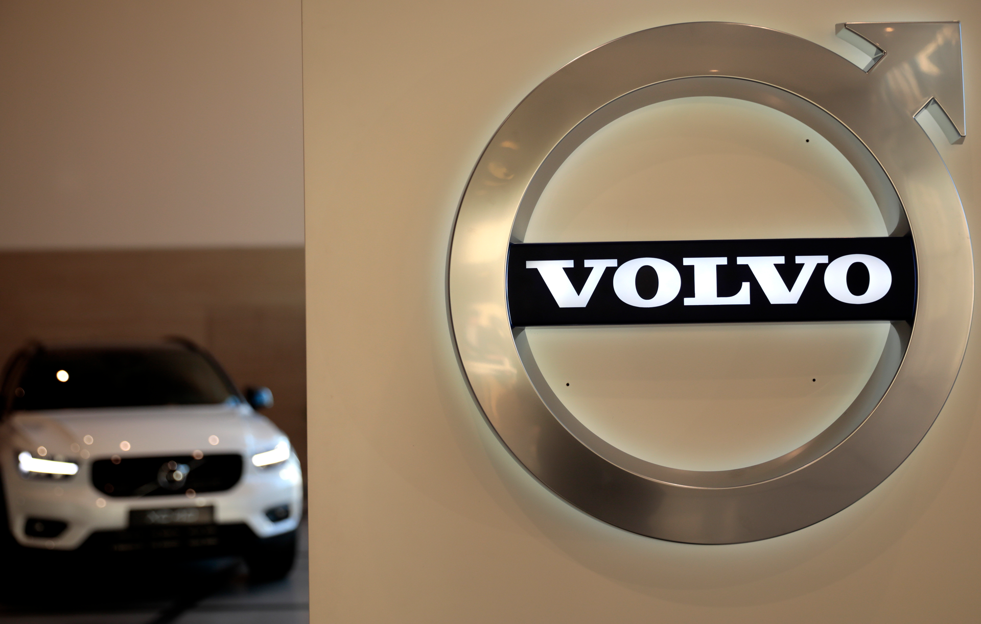 This file photo a Volvo car is parked behind the Volvo logo in the lobby of the company's corporate headquarters, in Brussels.