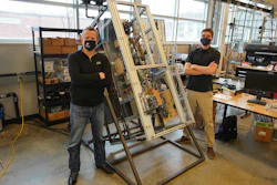 Purdue University researchers Eckhard Groll (left) and Leon Brendel stand next to a fridge experiment they designed to work in different orientations - even upside down.