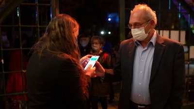 A man presents his 'green passport,' proof that he is vaccinated against the coronavirus, at the Khan Theater, Jerusalem, Feb. 23, 2021.