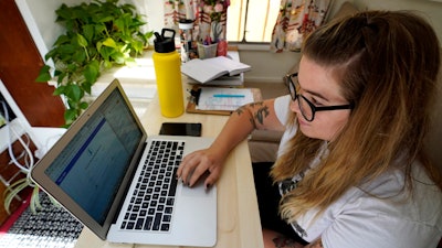 Kelly Mack works on her laptop to teach remotely from her home in Evanston, Ill., Sept. 2, 2020.