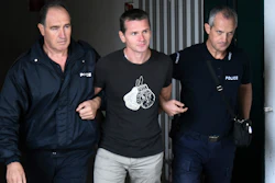 Alexander Vinnik is escorted by police officers from the courthouse in Thessaloniki, Greece, Sept. 29, 2017.