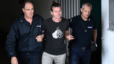 Alexander Vinnik is escorted by police officers from the courthouse in Thessaloniki, Greece, Sept. 29, 2017.