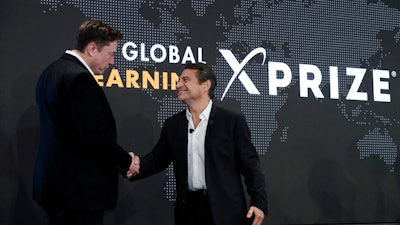 Tesla CEO Elon Musk, left, shakes hands with XPRIZE founder and Executive Chairman Peter Diamandis during the presentation of the XPRIZE for Children's Literacy in Los Angeles, May 15, 2019.