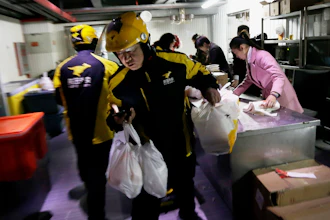 Meituan delivery workers prepare orders in Beijing, March 1, 2016.