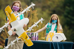 Girl Scouts Alice Goerlich, right, and Gracie Walker pose with a Wing delivery drone in Christiansburg, Va., April 14, 2021.