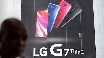 In this file photo, a visitor walks by an advertisement of LG Electronics' product at an electronic shop area in Seoul, South Korea.