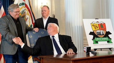 West Virginia Gov. Jim Justice, center, shakes hands with West Virginia Great Barrel Co. managing partners Tom Crabtree, left, and Philip Cornett at an announcement in Charleston, Oct. 19, 2017.