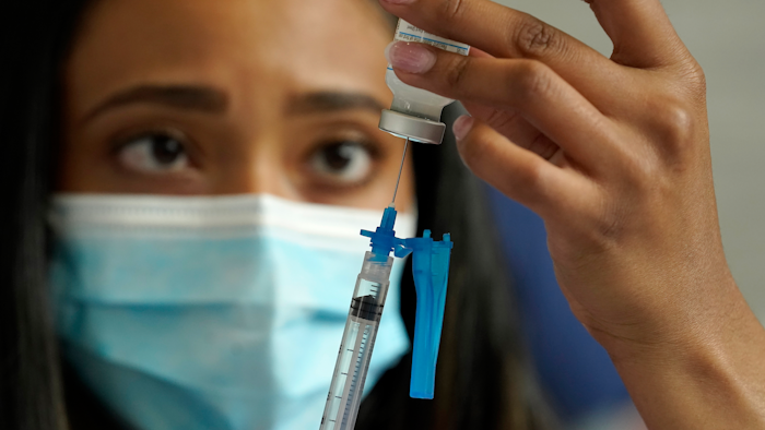 Licensed practical nurse Yokasta Castro draws a Moderna COVID-19 vaccine into a syringe at a mass vaccination clinic, Gillette Stadium, Foxborough, Mass., May 19, 2021.