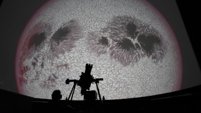 Researcher Ivannia Calvo, silhouetted against a solar satellite image, works inside the Solar Astronomical Observatory in San Jose, Costa Rica, April 30, 2021.