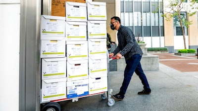 A member of Apple's legal team rolls exhibit boxes into the Ronald V. Dellums building in Oakland, Calif., May 3, 2021.