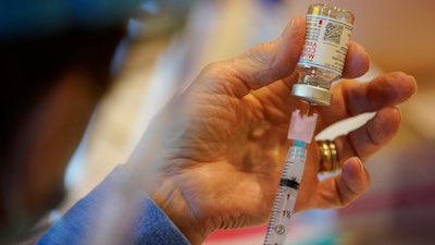 In this Dec. 29, 2020, file photo, Pat Moore, with the Chester County, Pa., Health Department, fills a syringe with Moderna COVID-19 vaccine before administering it to emergency medical workers and health care personnel at the Chester County Government Services Center in West Chester, Pa. The Biden administration’s call to lift patent protections on COVID-19 vaccines to help poor parts of the world get more doses has drawn praise from some countries and health advocates. But it has run into resistance from the pharmaceutical industry and others, who say that it won’t help curb the outbreak any time soon and will hurt future innovation.