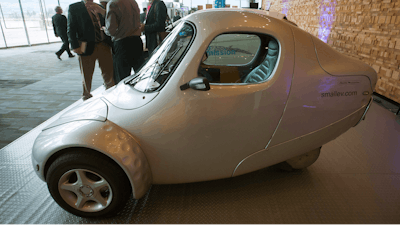 Delegates talk near an ElectraMeccanica single-user electric vehicle during the inaugural B.C. Tech Summit in Vancouver, B.C., on Monday, Jan. 18, 2016.