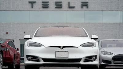 This Sunday, May 9, 2021 file photo shows vehicles at a Tesla location in Littleton, Colo. According to the U.S. National Transportation Safety Board, home security camera footage shows that the owner of a Tesla got into the driver's seat of the car shortly before a deadly crash in suburban Houston. But the preliminary report on the crash that killed two men doesn't explain why police found no one behind the wheel of the car, which burst into flames after crashing about 550 feet (170 meters) from the owner's home.
