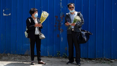 Wei Xiuwen, left, mother of Chen Mei, chats with Cai Jianli, father of Cai Wei, outside a courthouse in Beijing, May 11, 2021.