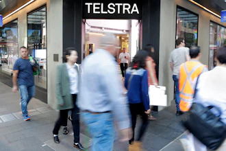 Pedestrians walk pasy a Telstra store in Sydney, May 13, 2021.