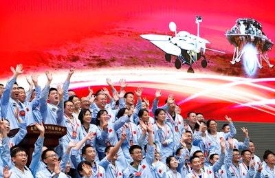 Members at the Beijing Aerospace Control Center celebrate after China's Tianwen-1 probe successfully landed on Mars, May 15, 2021.