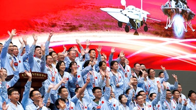 Members at the Beijing Aerospace Control Center celebrate after China's Tianwen-1 probe successfully landed on Mars, May 15, 2021.