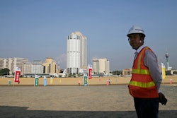 A construction worker stands on land that was reclaimed from the Indian Ocean for the Colombo Port City project, Colombo, Sri Lanka, Jan. 2, 2018.