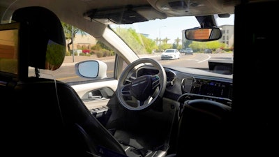 A Waymo minivan moves along a city street during an autonomous vehicle ride, April 7, 2021, Chandler, Ariz.