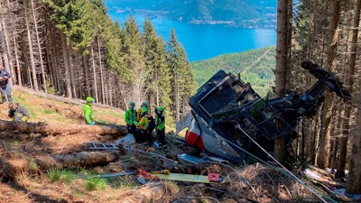 Rescuers work by the wreckage of a cable car after it collapsed near the summit of the Stresa-Mottarone line in the Piedmont region, northern Italy, May 23, 2021.