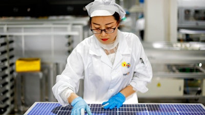 An employee works at a solar panel and equipment factory in Jiujiang, China, Jan. 5, 2021.