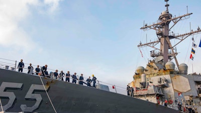 In this photo provided by the U.S. Navy, sailors aboard the guided missile destroyer USS Stout handle mooring lines during the ship's return to home port at Naval Station Norfolk, in Norfolk, Va., in this Oct. 12, 2020, photo. The USS Stout showed rust as it returned from the 210-day deployment. The rust was quickly removed and the ship repainted. But the rusty ship and its weary crew underscored the costly toll of deferred maintenance on ships and long deployments on sailors.