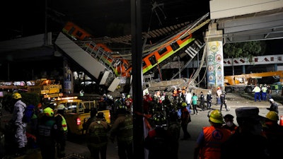 Mexico City's subway cars lay at an angle after a section of Line 12 of the subway collapsed in Mexico City, Tuesday, May 4, 2021. The section passing over a road in southern Mexico City collapsed Monday night, dropping a subway train, trapping cars, and causing at least 50 injuries and several dead, authorities said.