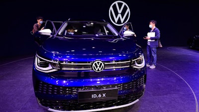 In this April 20, 2021 file photo, visitors look at the latest electric car from Volkswagen during the Shanghai Auto Show in Shanghai, China. Volkswagen's earnings bounced back strongly in the first quarter. The company is riding the strong recovery from the pandemic in China, its single biggest market these days.