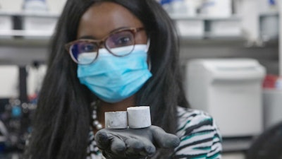 Professor Ange-Therese Akono holds a sample of her smart cement.