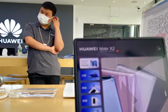 A worker waits for customers inside a Huawei store in Beijing, June 2, 2021.