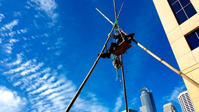A protester suspended at the top of a tepee erected outside Wells Fargo in downtown Minneapolis during a protest against Enbridge Energy's planned Line 3 replacement crude oil pipeline, Oct. 4, 2018.