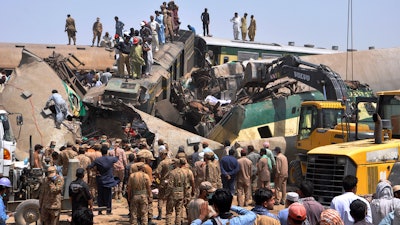 Soldiers and volunteers work at the site of a train collision in the Ghotki district in southern Pakistan, June 7, 2021.