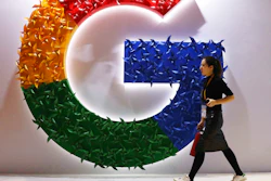 A woman walks past the Google logo at the China International Import Expo in Shanghai, Nov. 5, 2018.